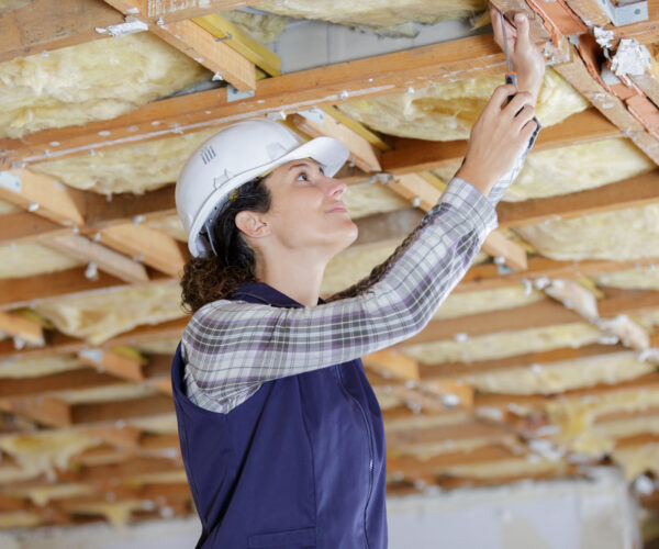 female builder working on wooden ceiling supports