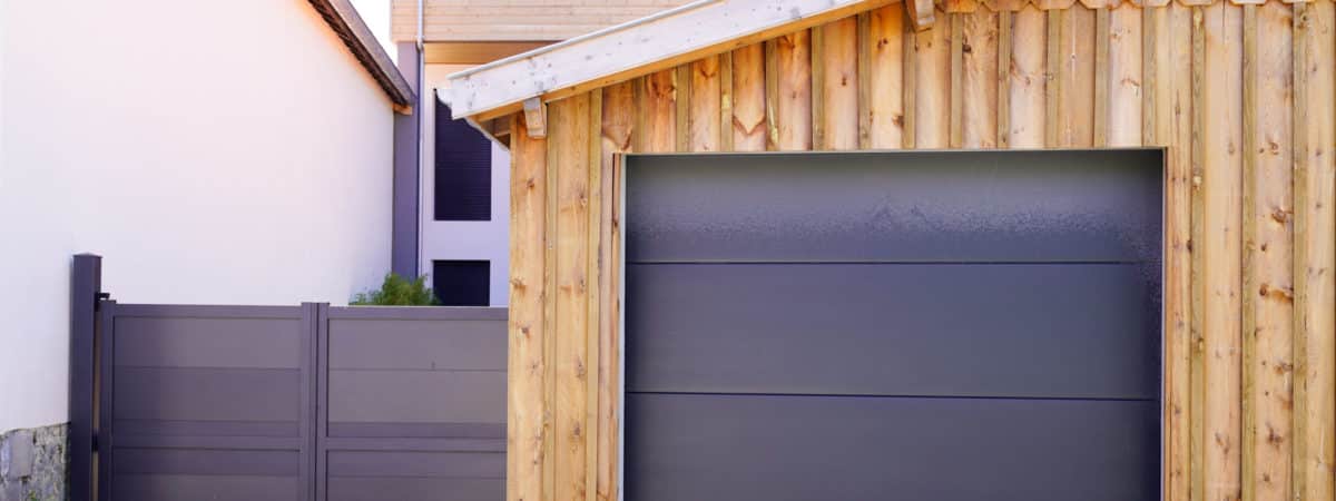 Aluminum modern home with grey gate portal and modern garage door of wooden house